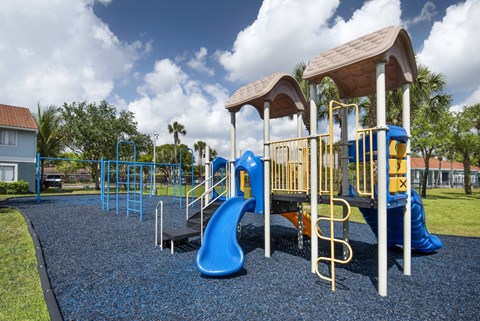 A playground with a blue slide and yellow railings.