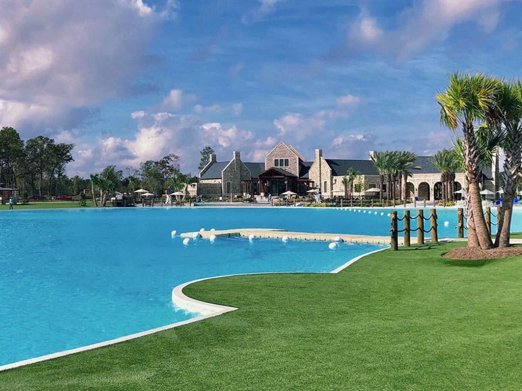 a large pool with a house in the background