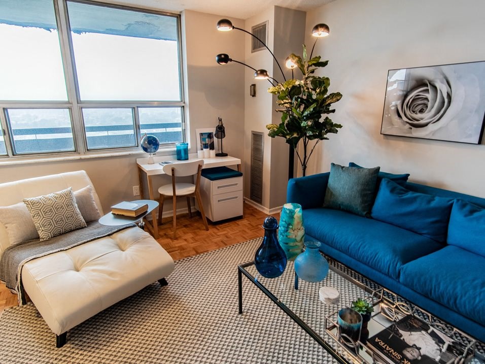 a living room with a blue couch and a window