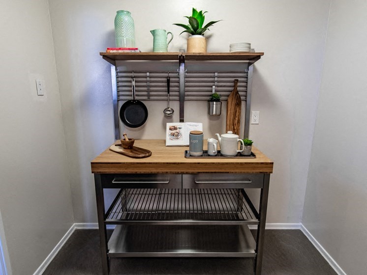a kitchen with a table and a shelf with pots and pans