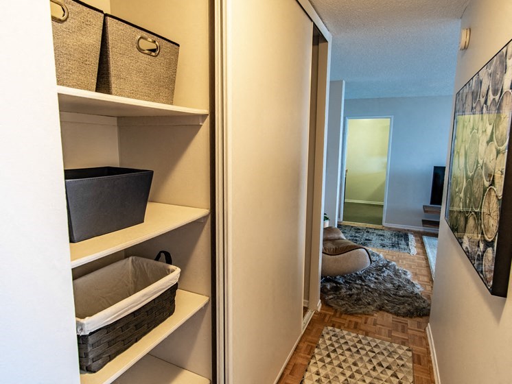a walk in closet with baskets and a mirror in a house