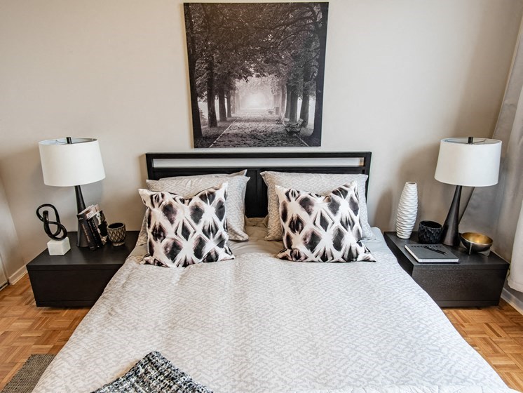 a bedroom with a bed with pillows and a picture on the wall