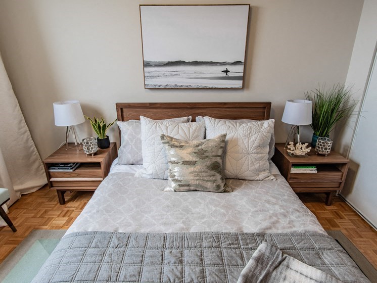 a bedroom with a bed with pillows and a picture on the wall
