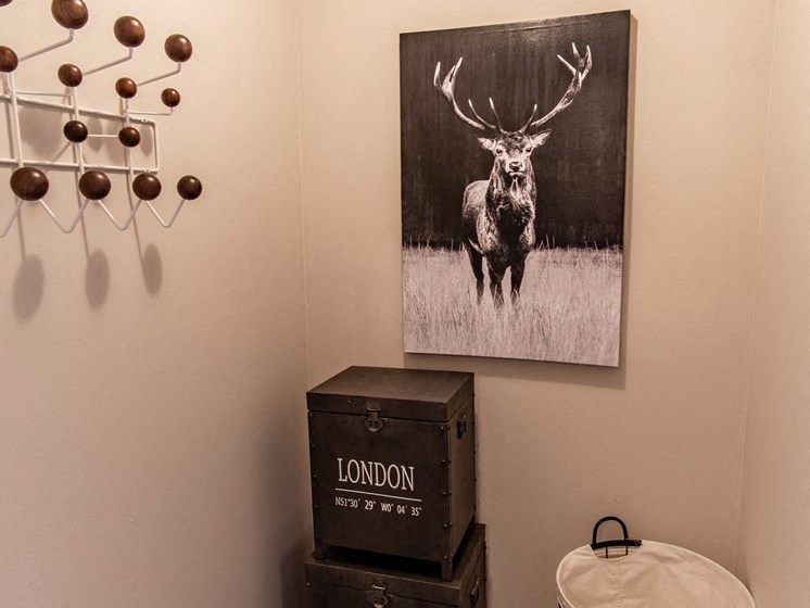 a bathroom with a picture of a deer on the wall
