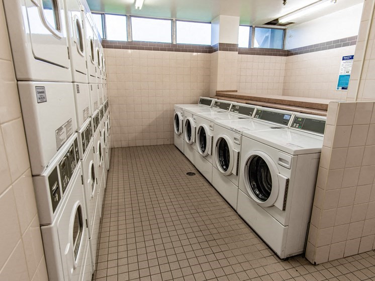 a row of washers and dryers in a laundry room