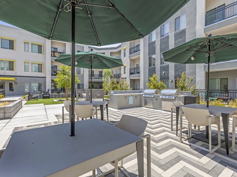 A patio with tables and chairs under umbrellas.
