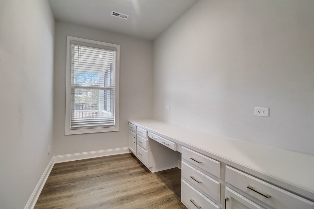a bedroom with a desk and a window