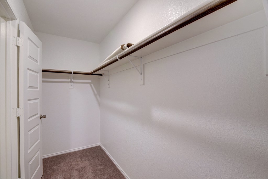 an empty closet in a bedroom with a white door