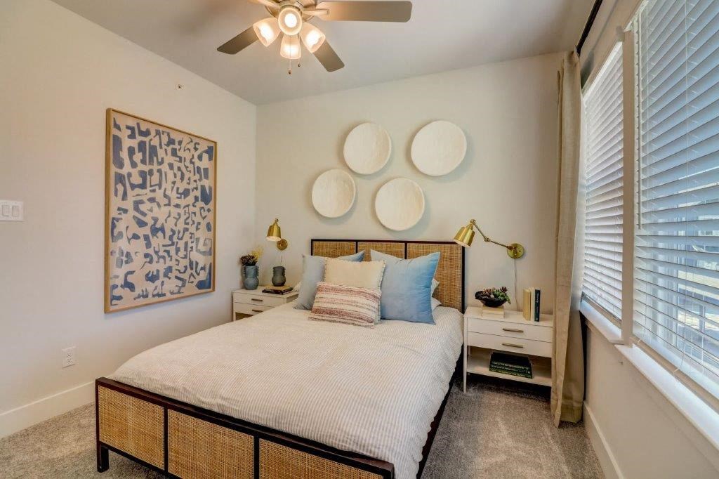 1 Bedroom Single Family Homes for Rent in Hurst TX - Mission Town Square - Bedroom with Plush Carpet, a Ceiling Fan, and Large Windows