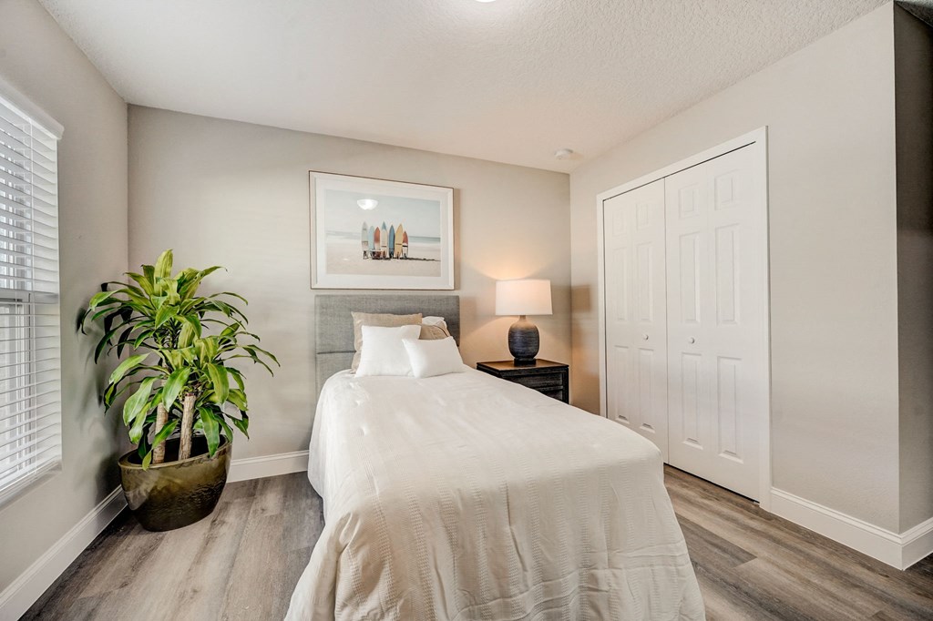 Houses in Lady Lake for Rent – The Groves at Lake Ella - guest bedroom with hardwood floors and a bed