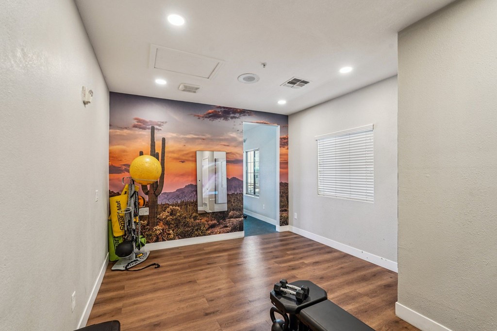 A room with a wall mural of a desert scene and a bench.