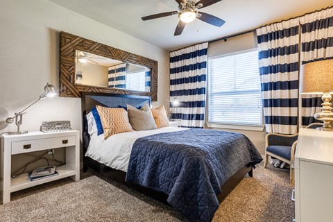 Beautifully designed guest bedroom at 33hundred Apartments in Austin TX with large windows and modern décor.