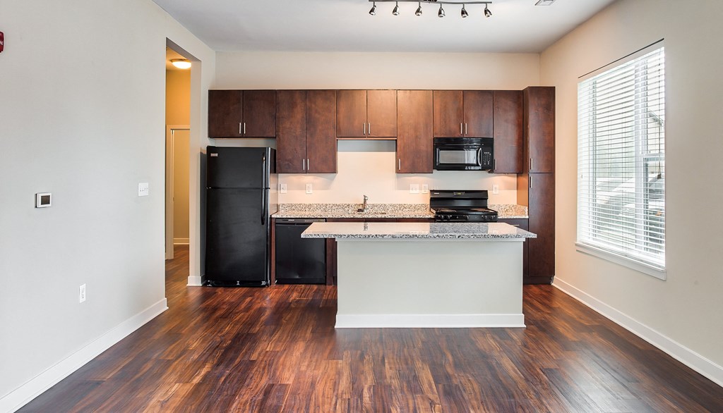 a kitchen with dark wood cabinets and a white island with granite countertops