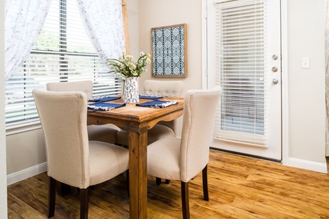 A dining room with a wooden table and chairs.
