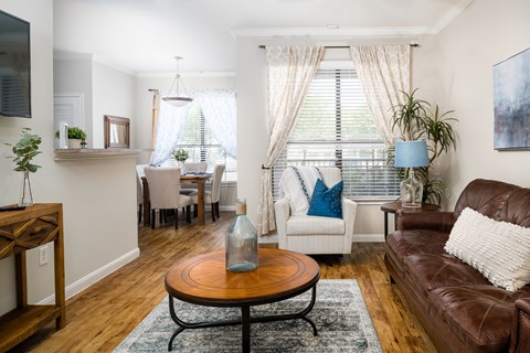 A living room with a brown leather couch and a wooden coffee table.