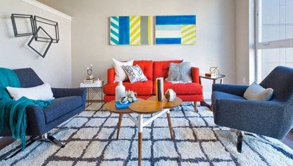a living room with a red couch and two blue chairs at Astro Apartments, Seattle, WA