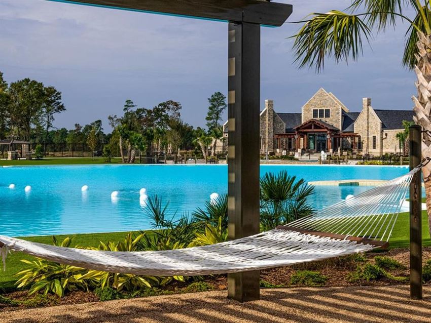 a hammock in front of a pool with a house in the background - Photo Gallery