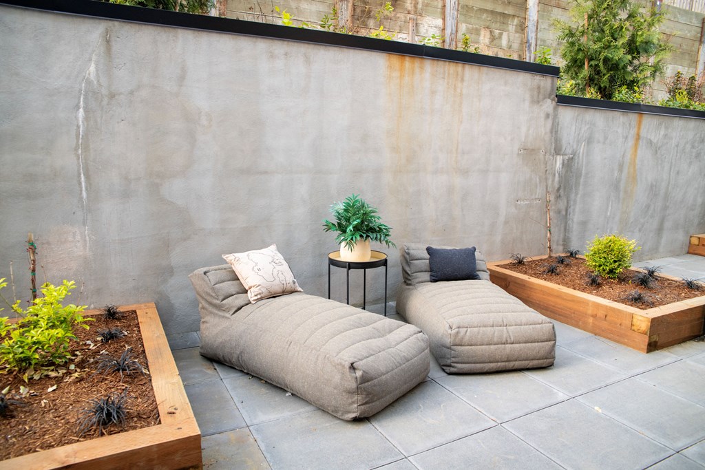 a courtyard with two couches and a table and plants