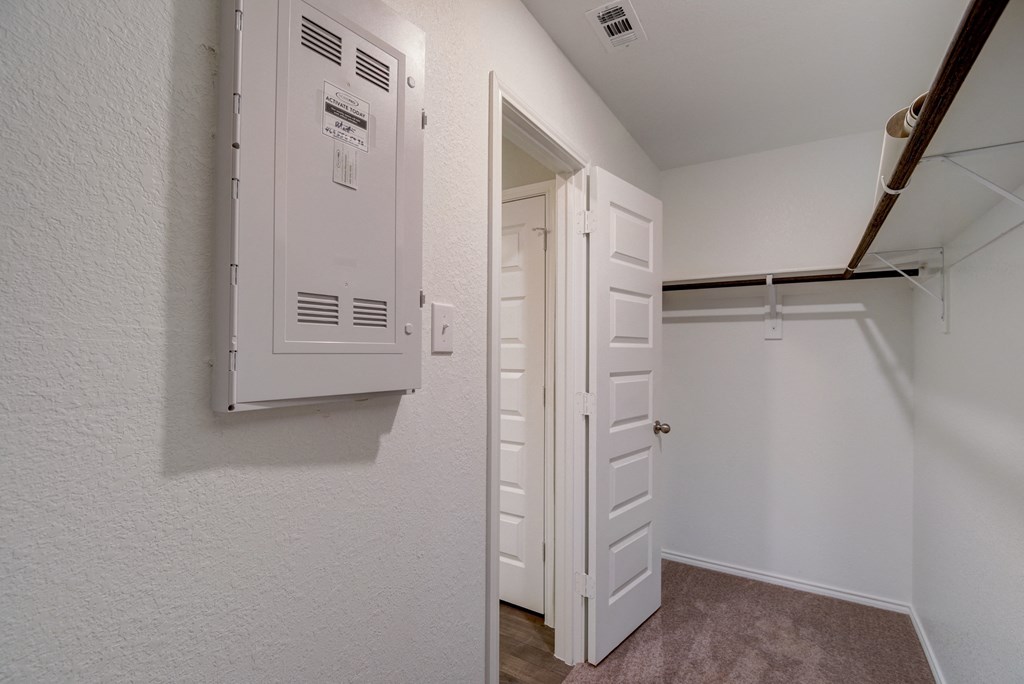 an empty closet and a white door in a room with a wall mounted air conditioning