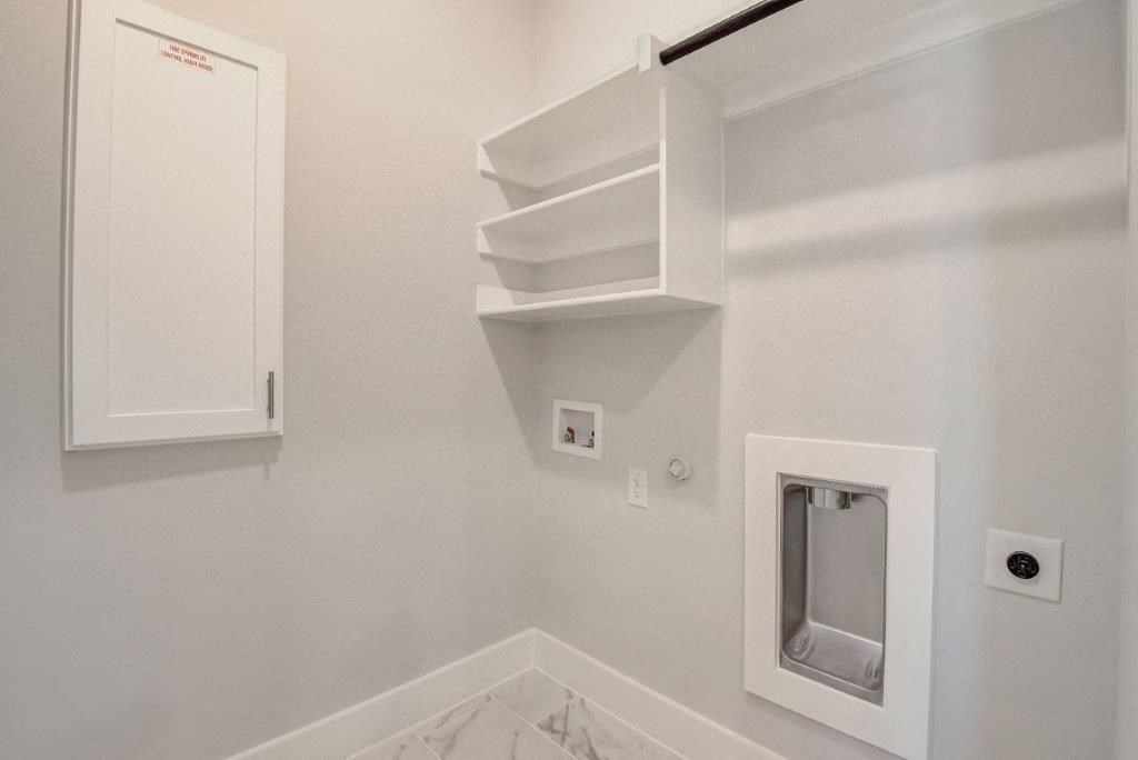 a white bathroom with a urinal and shelves on the wall