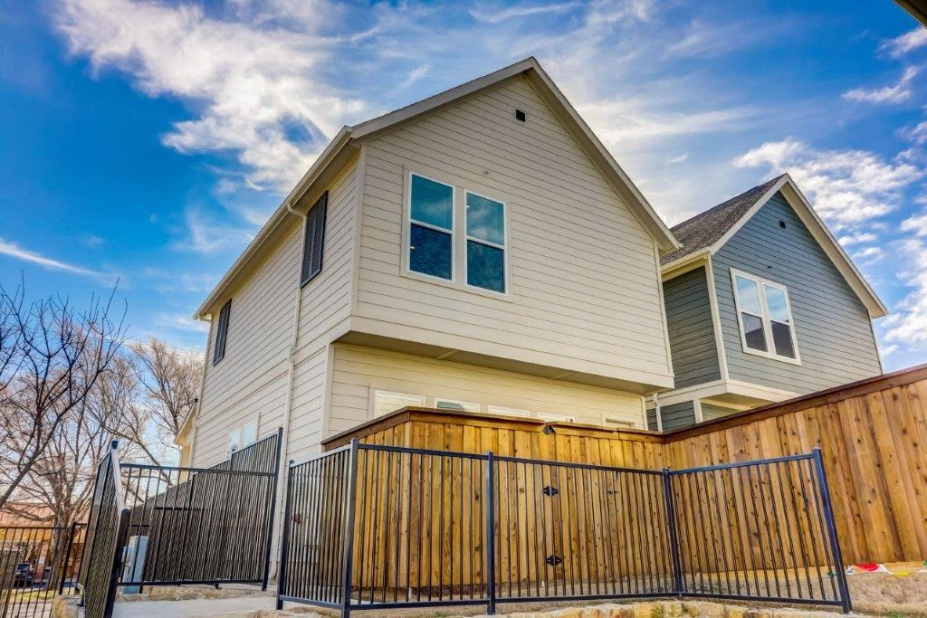 the front of a house with a fence and a gate