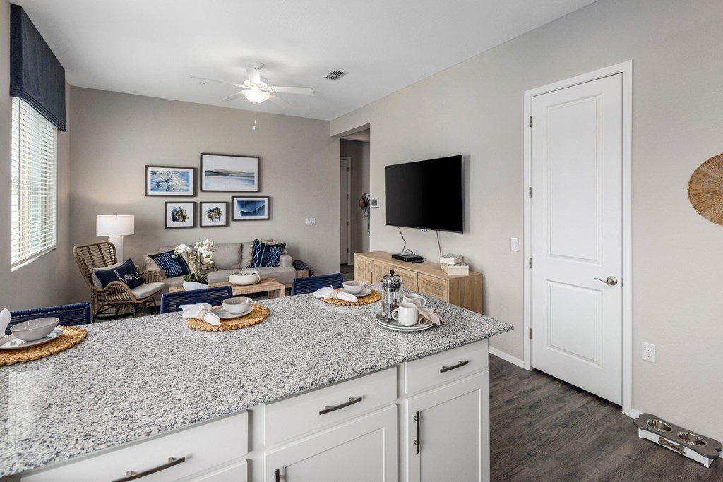 A kitchen with granite countertops and white cabinets.