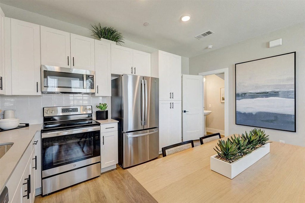 a kitchen with white cabinets and stainless steel appliances