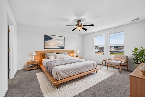 A bedroom with a large bed and a ceiling fan.
