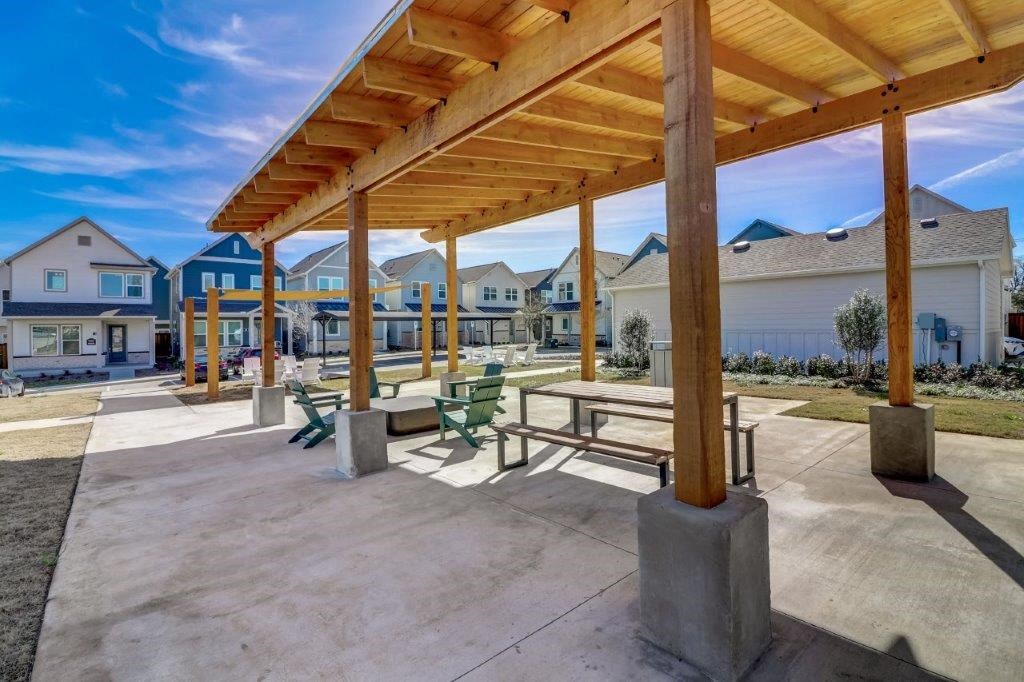 a picnic area with benches under a wooden roof