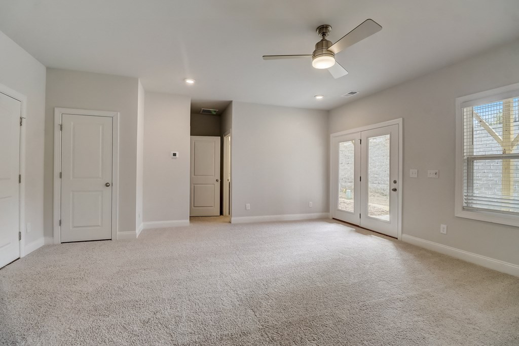 an empty living room with a ceiling fan