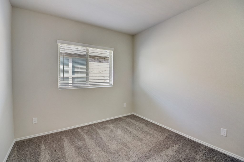 an empty room with carpet and a window