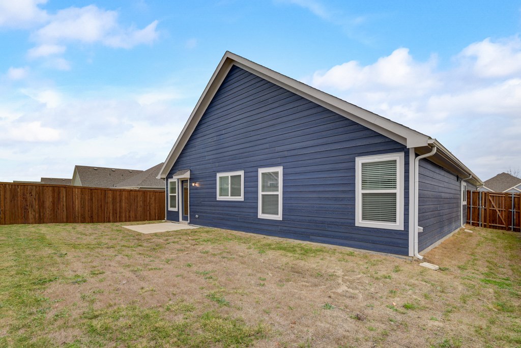 a blue house with a yard and a wooden fence