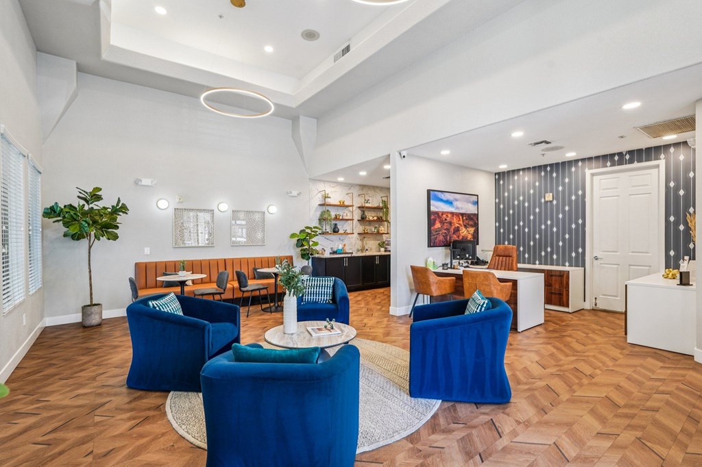 A living room with blue chairs and a white coffee table.