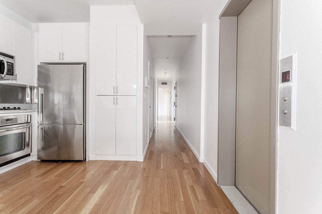 a renovated kitchen with white cabinets and stainless steel appliances