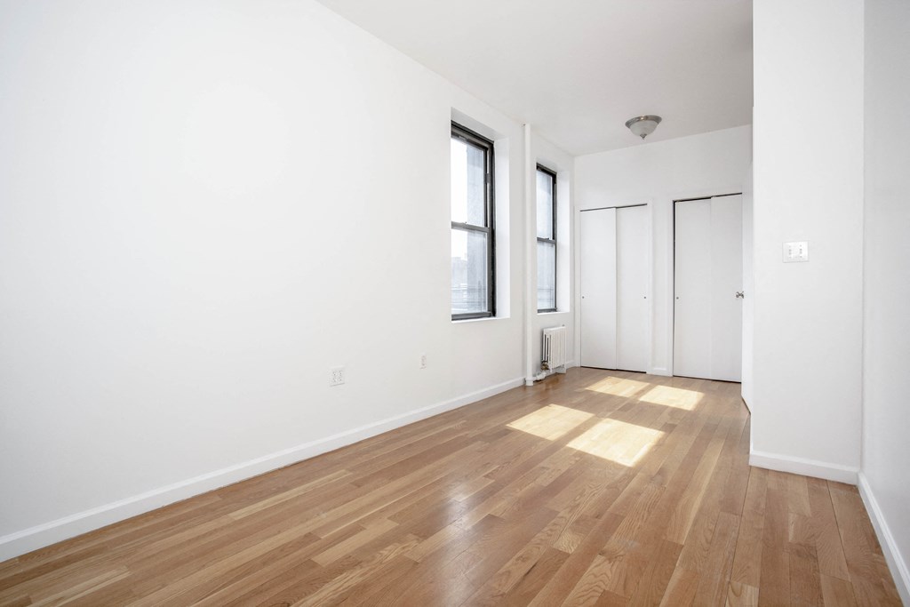 an empty living room with white walls and wooden floors