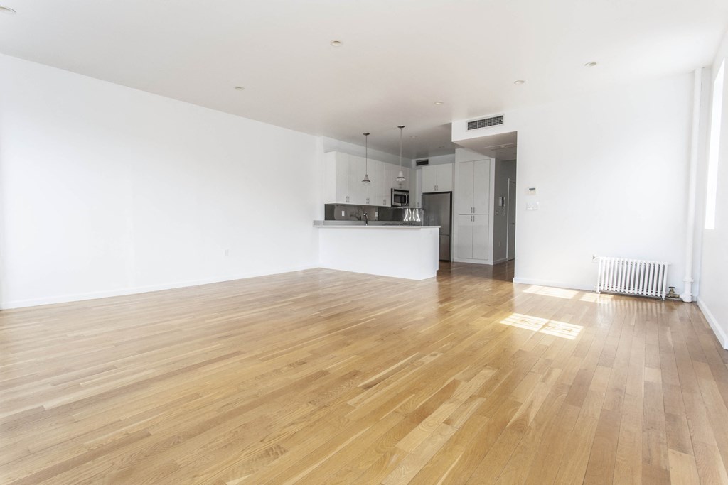 an empty living room with white walls and wooden floors