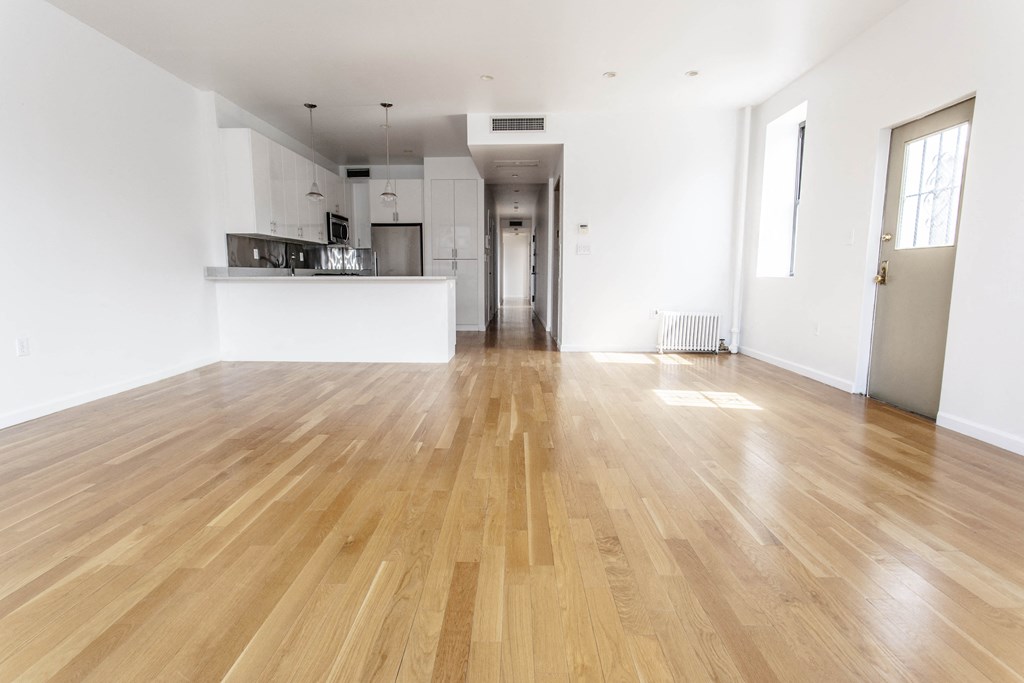 a living room with a hard wood floor and a kitchen