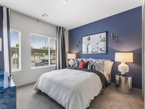 A bedroom with a large bed and a picture on the wall.