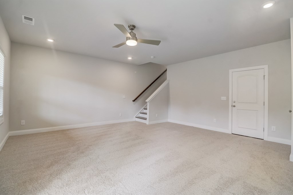 a bedroom with white carpet and a white door and a ceiling fan