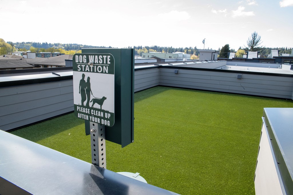 a grassy roof top with a sign for a dog waste station and a roof