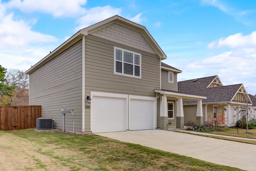 a beige house with a garage and a driveway
