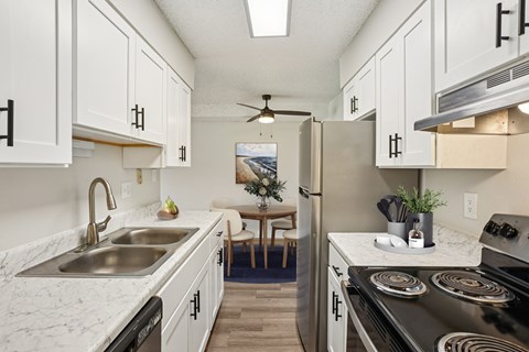 A kitchen with white cabinets and a black stove top oven.