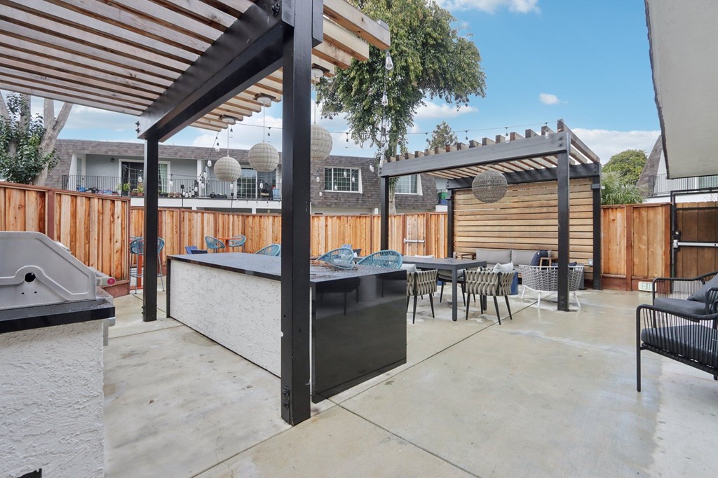 A patio with a barbecue grill and seating area.