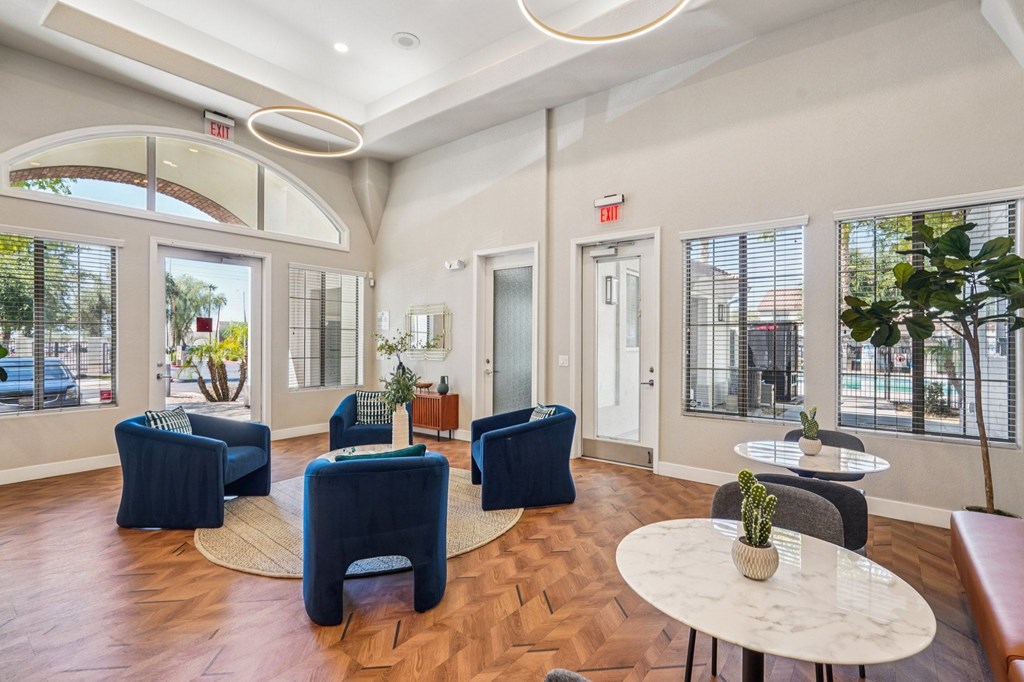 A spacious room with blue chairs and a white table.