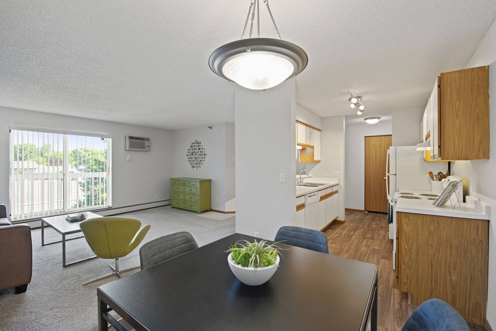 the view of a living room and kitchen from a dining room table