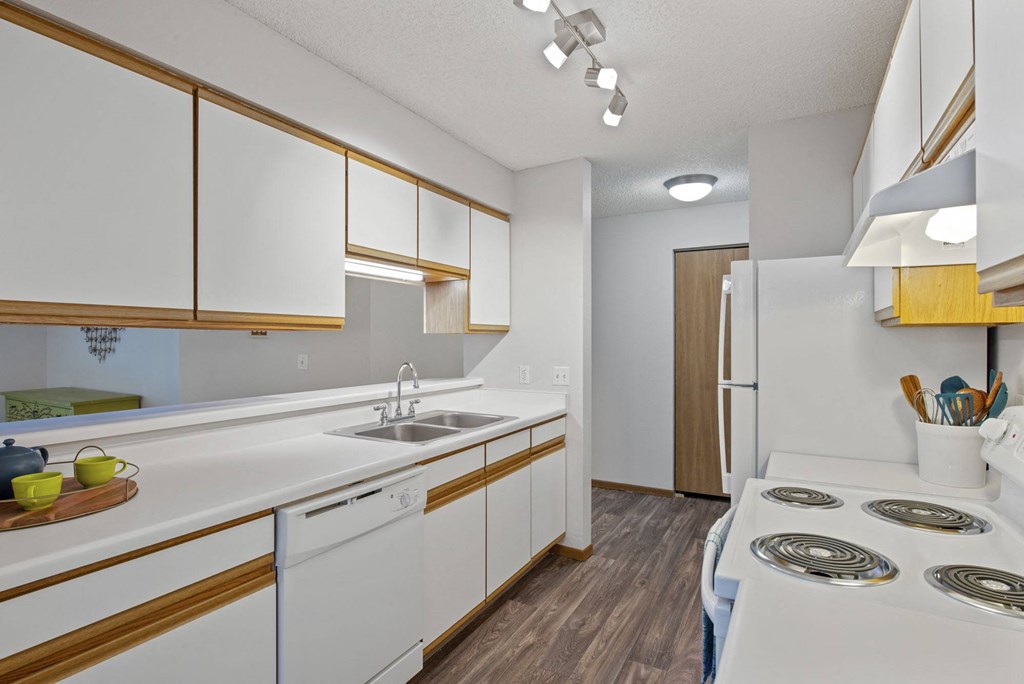 a kitchen with white appliances and wood floors