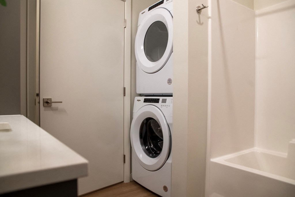 a front loading washer and dryer in a closet in a bathroom