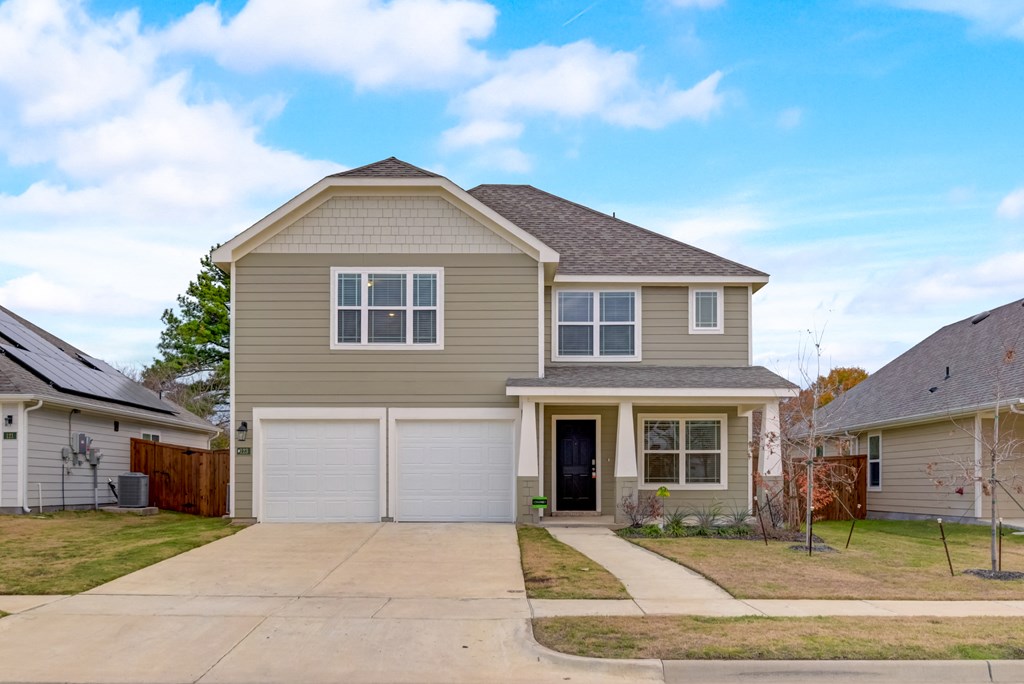 a beige house with a garage and a driveway