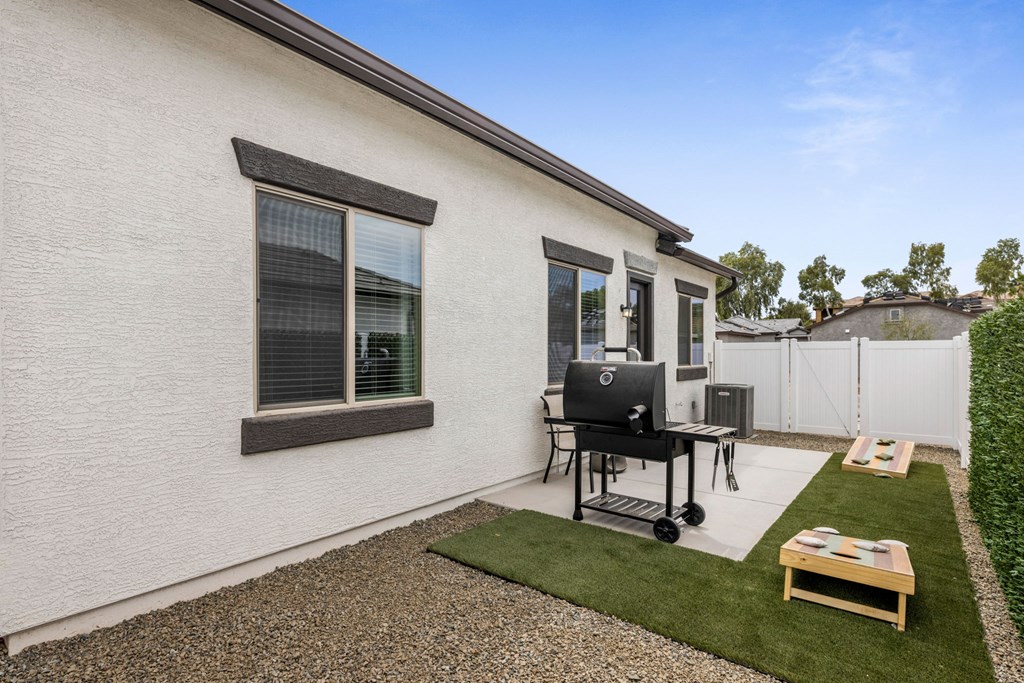 A small white house with a black chair and table outside.