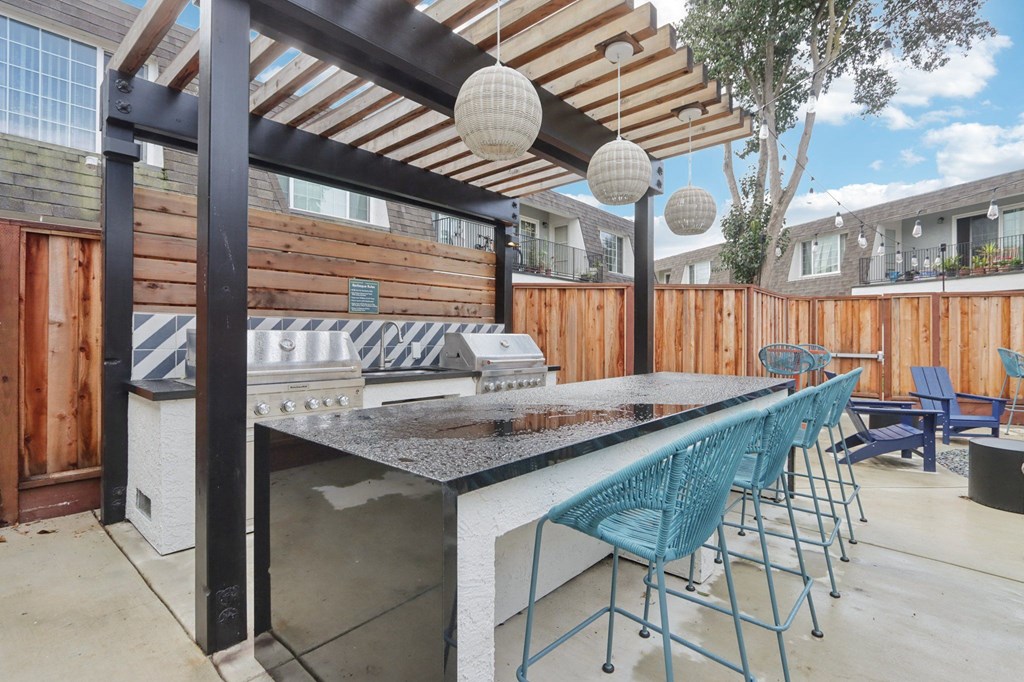 Fremont, CA Studios For Rent - Brookvale Chateau - Outdoor BBQ Area With Two Grills, A Sink,  A Bar Area, High-Top Seating, And Strung Lights